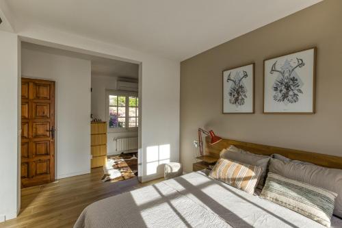 a bedroom with a large bed with two pictures on the wall at Villa Les Aulines in Calonge