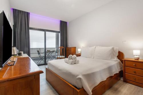 a bedroom with a bed with two towels on it at Paraiso Madeira - Suites in Gaula