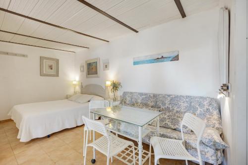 a room with a bed and a table and chairs at La Posada de la Pinaleta in Chiclana de la Frontera