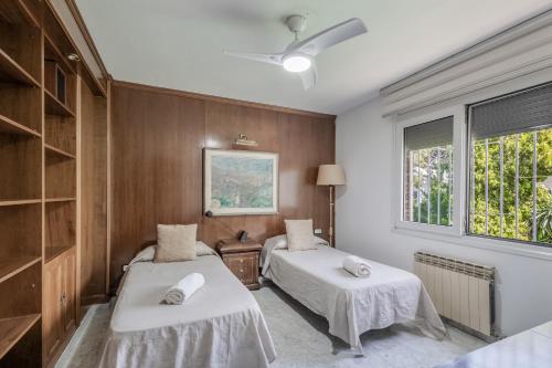 a bedroom with two beds and a window at Villa Masnou in El Masnou
