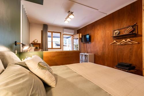 a bedroom with a bed and a window and a tv at Les Ptis Chiffons in Lacanau