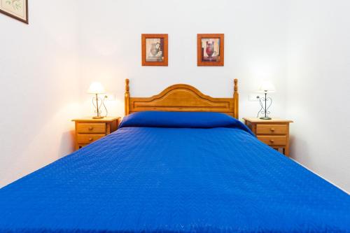 a bedroom with a blue bed with two night stands at Chalet Bellavista in Conil de la Frontera