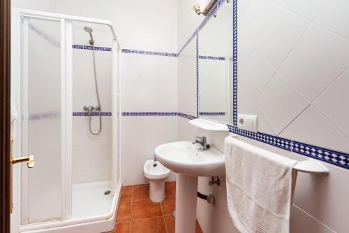a white bathroom with a sink and a shower at Chalet Bellavista in Conil de la Frontera