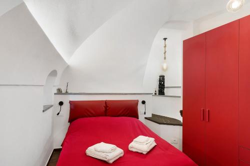 a bedroom with a red bed with two towels on it at Casa vacanza A Cola - con Jacuzzi in Rocchetta Nervina