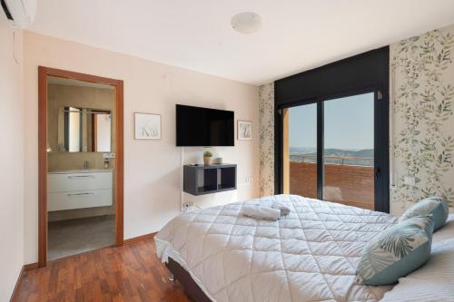 a bedroom with a large bed and a television at Villa Can Camarassa in Cervelló