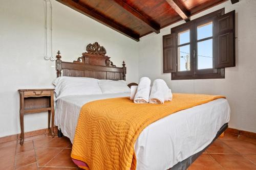 a bedroom with two beds and a table and a window at Casa Rural Benjamin en Deltebre in Deltebre
