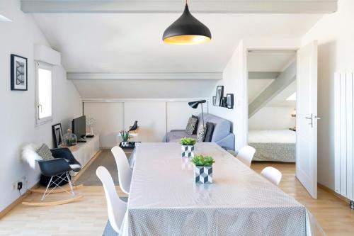 a dining room and living room with a table and chairs at Charmant T2 centre Capbreton in Capbreton