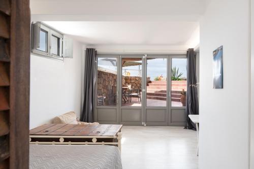 a room with a bed and a sliding glass door at Luna Rossa Milos - Lavender in Provatas