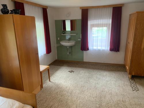 a bathroom with a sink and a mirror and a bedroom at Ferienwohnung Durst 2 in Mayrhofen
