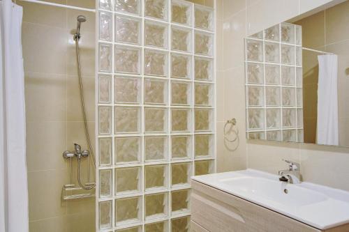 a bathroom with a shower with a sink and a mirror at Ca Luis in Mogán