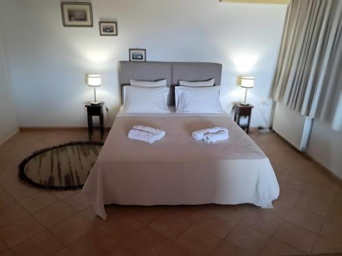 a bedroom with a bed with two towels on it at A View From The Attic Window in Kyparissia