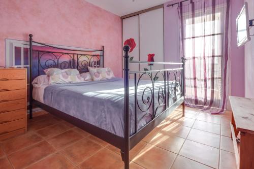 a bedroom with a bed with a wrought iron frame at La Casa De Enzo in Playa de las Americas