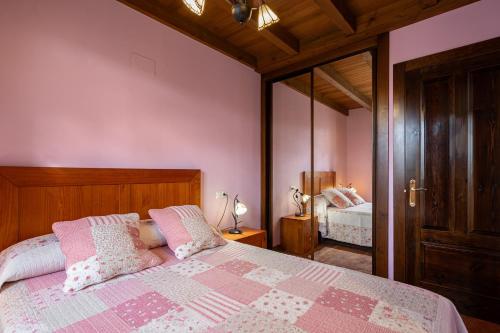 a bedroom with a bed with pink walls and a mirror at Apto Rosa - Casa el gaitero in Susacasa
