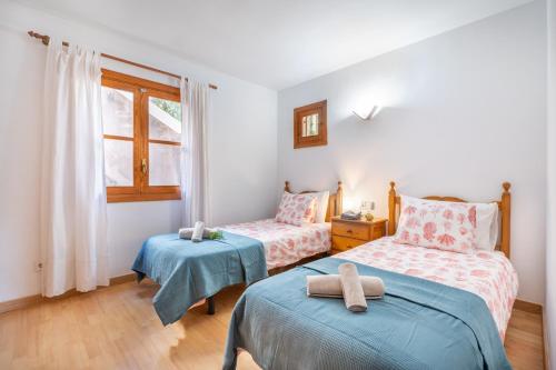a bedroom with two beds and a window at Vistasol Port de Soller in Sóller