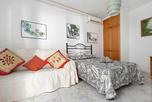 a bedroom with a bed and a couch at Casa Auxilia in Araya