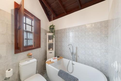 a bathroom with a white tub and a toilet at El Bebedero de Los Sauces in San Andres y Sauces