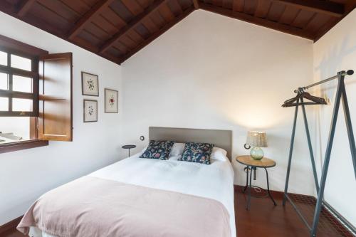 a bedroom with a white bed and a table at El Bebedero de Los Sauces in San Andres y Sauces