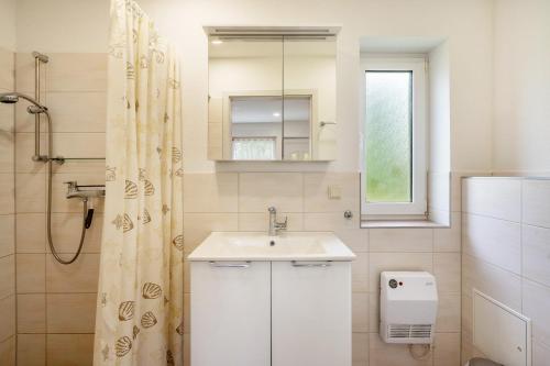 a white bathroom with a sink and a shower at Bungalow 91 in Zeulenroda