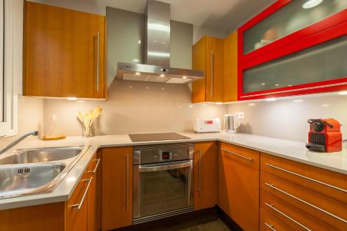 a kitchen with wooden cabinets and a sink at Lemon Tree Apartment in Canet de Mar