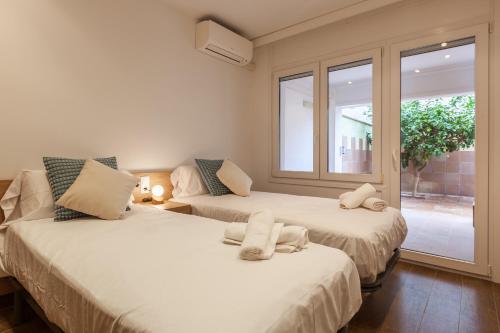 two beds in a room with a window at Lemon Tree Apartment in Canet de Mar