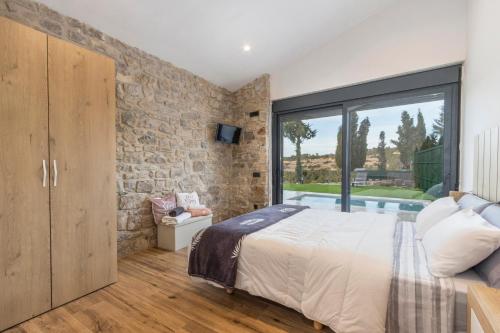 a bedroom with a stone wall and a large bed at Cantó el Sech in Montoliu de Segarra