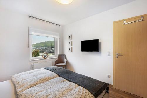 a bedroom with a bed and a window and a television at Ferienwohnung Kraus in Katzenbach