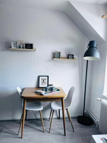 a dining room table with two chairs and a lamp at Studio Pergaud in Besançon