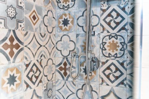 a bathroom with a shower with blue and white tiles at Villa Balbi in Torre delle Stelle