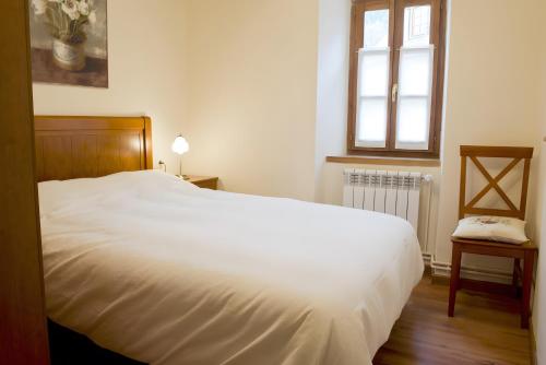 a bedroom with a white bed and a window at Ço de Carles in Garós