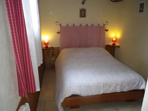 a bedroom with a bed and two lamps on tables at Gîte Champêtre, Tout Confort in Saint-Éloy-la-Glacière