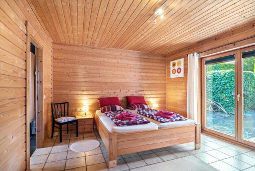 a room with a bed in a wooden cabin at Landhaus-Eifelhöhe in Schüller