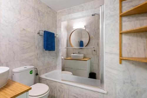 a bathroom with a toilet and a sink and a mirror at Plata Centro in Torremolinos