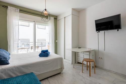 a bedroom with a bed and a tv on a wall at Plata Centro in Torremolinos