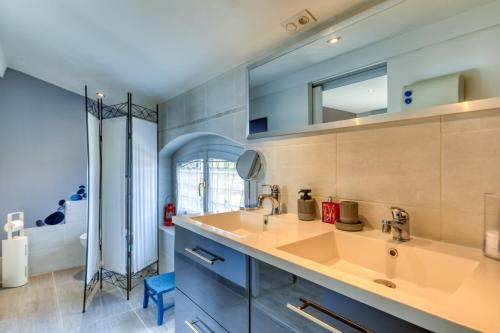 a bathroom with two sinks and a mirror at Villa Angelo - Olive Verte in Saint-Thibéry