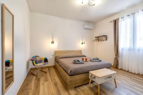 a bedroom with a bed and a table and a mirror at New and Vintage Villa - Anni 70' in Alghero