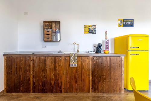a kitchen with a wooden counter and a yellow refrigerator at New and Vintage Villa - Anni 70' in Alghero