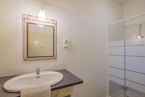 a white bathroom with a sink and a mirror at Gîte Des Louveteaux in Banne