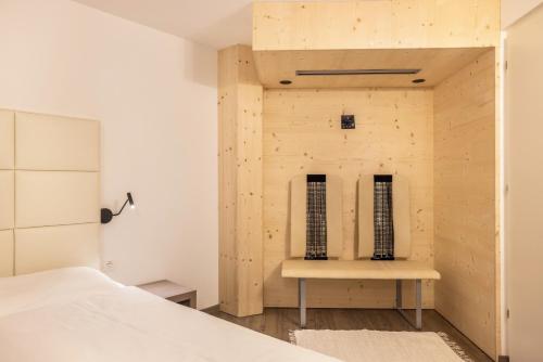 a room with a bed and a wooden wall at Apartment Ön Residence Bun Ste in San Vigilio Di Marebbe