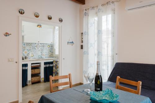 a dining room with a table with a bottle of wine at Casa Del Pescatore in Trappeto