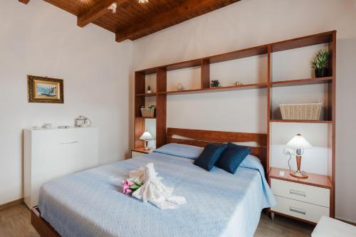 a bedroom with a bed with blue sheets and blue pillows at Casa Del Pescatore in Trappeto