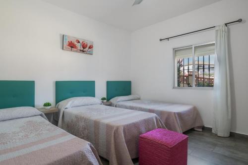 a room with three beds and a window at Casa La Muela in La Muela