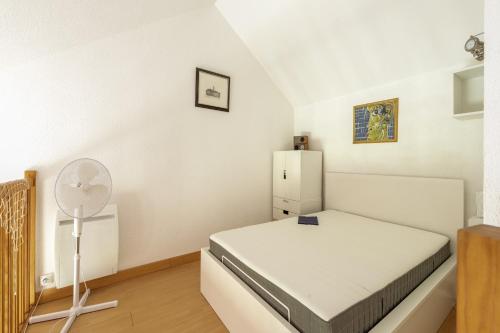 a small bedroom with a bed and a refrigerator at La Cabine du Marin - 73 in Pornic