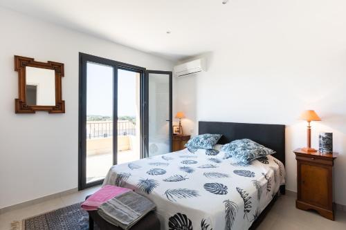 a bedroom with a bed and a large window at Chambre D'hôtes À Losari in Palasca