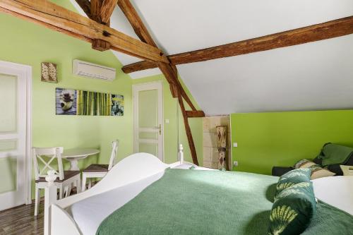 a green bedroom with a bed and a table at Le Pressoir Gîte 8 Pers in Saint-Georges-sur-Cher
