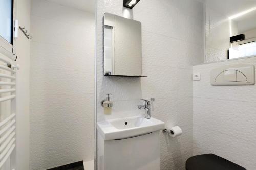 a white bathroom with a sink and a toilet at Chambre D'hôtes Toi Et Moi - in Pornic