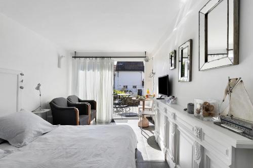a white bedroom with a bed and a chair at Chambre D'hôtes Toi Et Moi - in Pornic