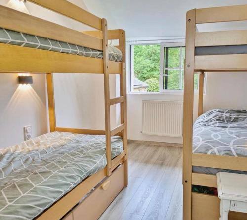 a bedroom with two bunk beds and a window at Gîte du moulin de Tanis in Oisseau