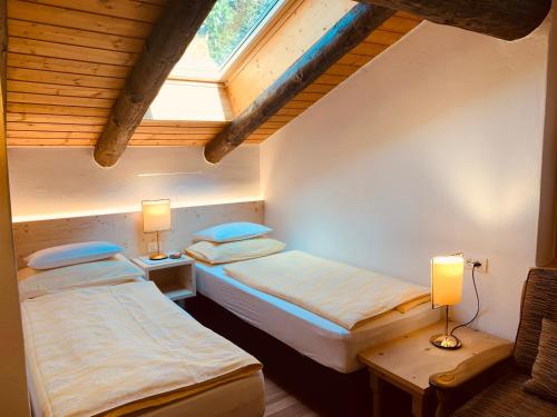 two twin beds in a room with a window at Chalet Marianna in Meltina