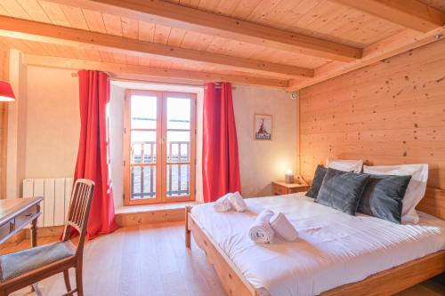 a bedroom with a large bed with red curtains at Chalet Reves des Cimes in Praranger