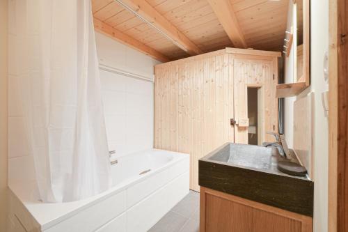 a bathroom with a bath tub and a sink and a bath tub at Chalet Reves des Cimes in Praranger
